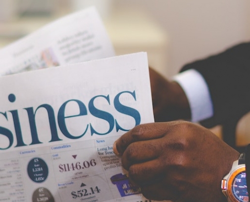 Blog header image of a businessman reading the business news for 13 recommended CPM software tools for effective KPI management blog from Solver